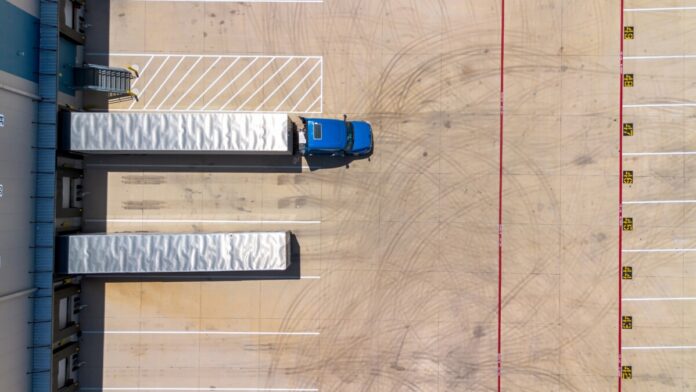 Logistics warehouse exterior with loading bays and truck