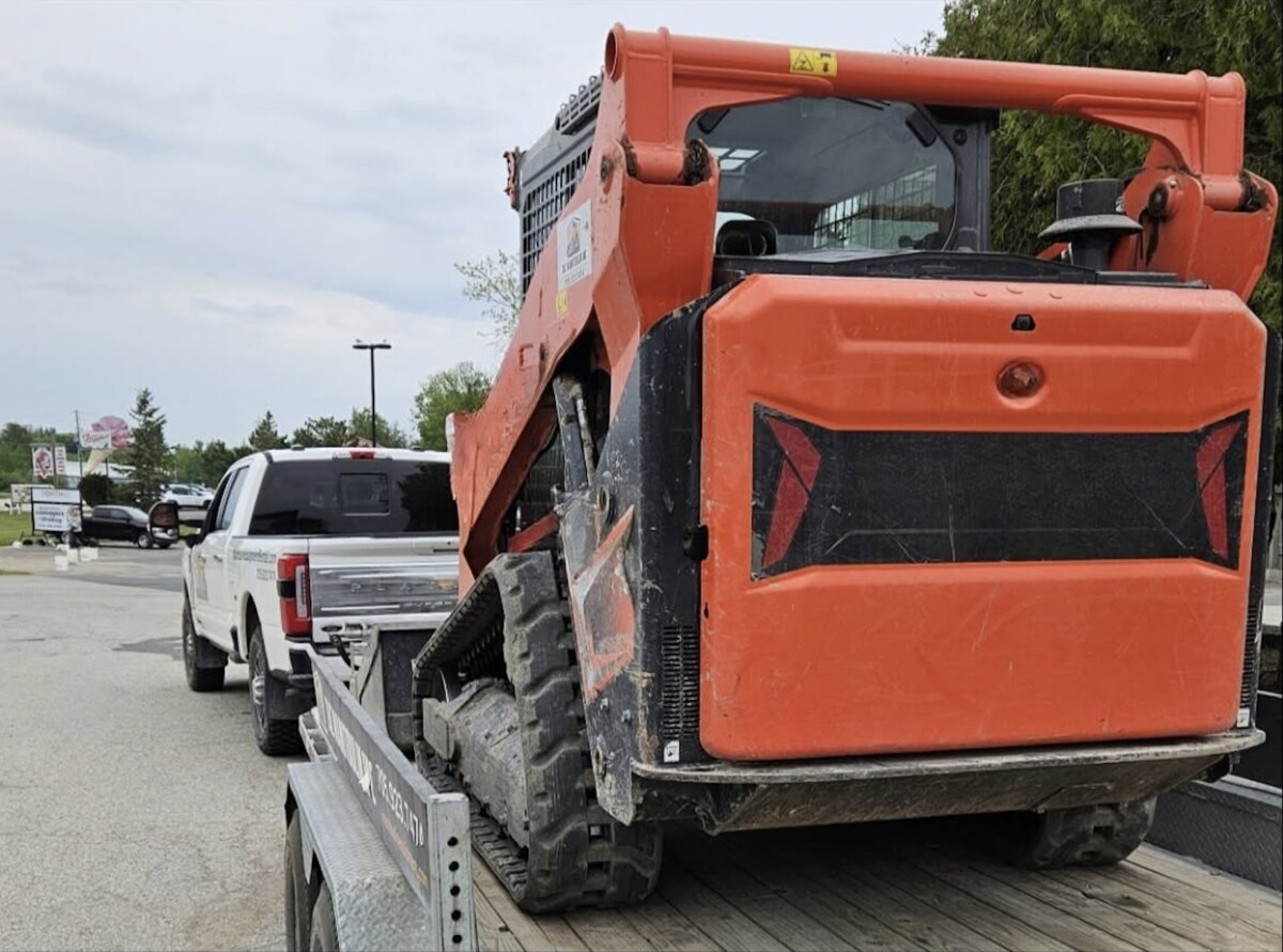 Several charges issued for hauling skid steer ‘with no visible straps’
